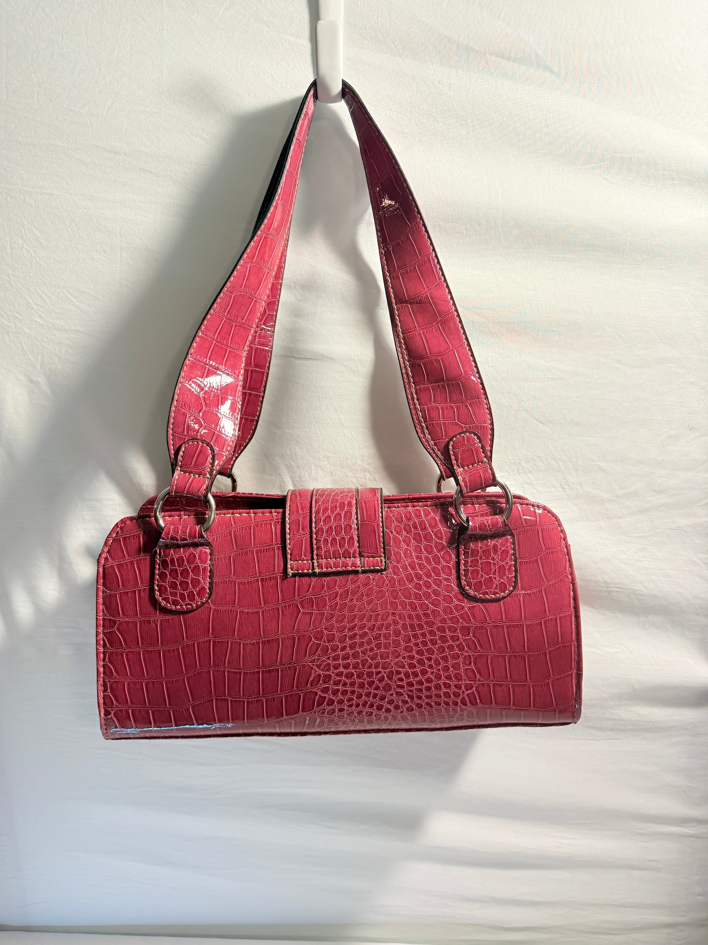Pre-owned. Crocodile-embossed burgundy patent leather shoulder bag with silver-tone hardware and zipper closure.