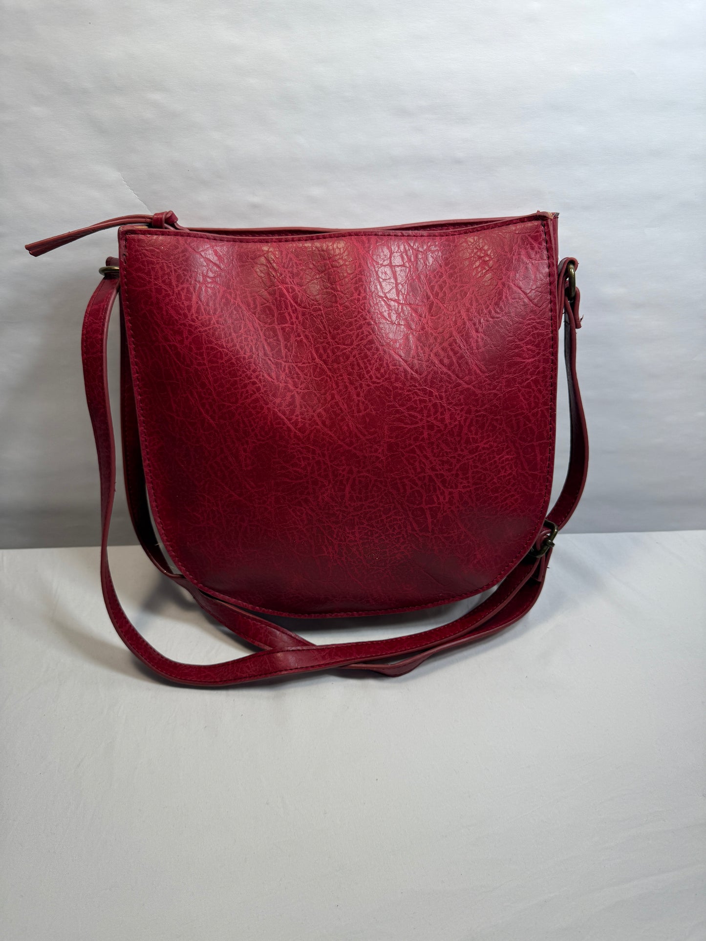 Crossbody Red Faux leather bag w/adjustable strap and side pocket.