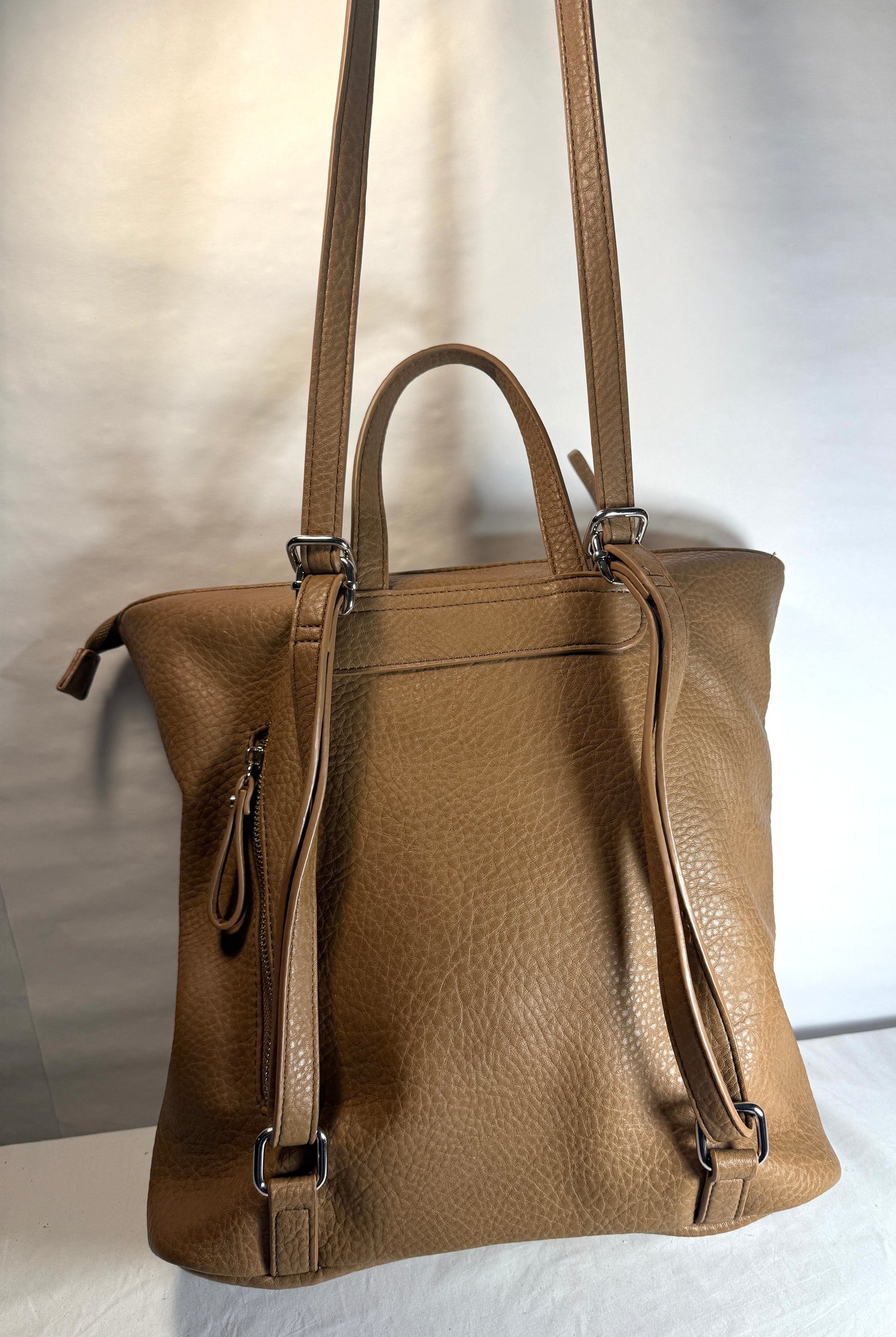 Vegan leather backpack w/functional strap that allows use as a backpack or a crossbody bag.  